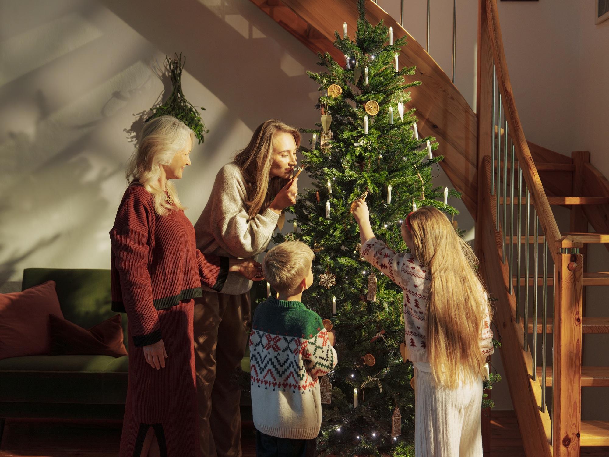 Familie schmückt gemeinsam den FairyTrees FT33 Weihnachtsbaum für das Fest
