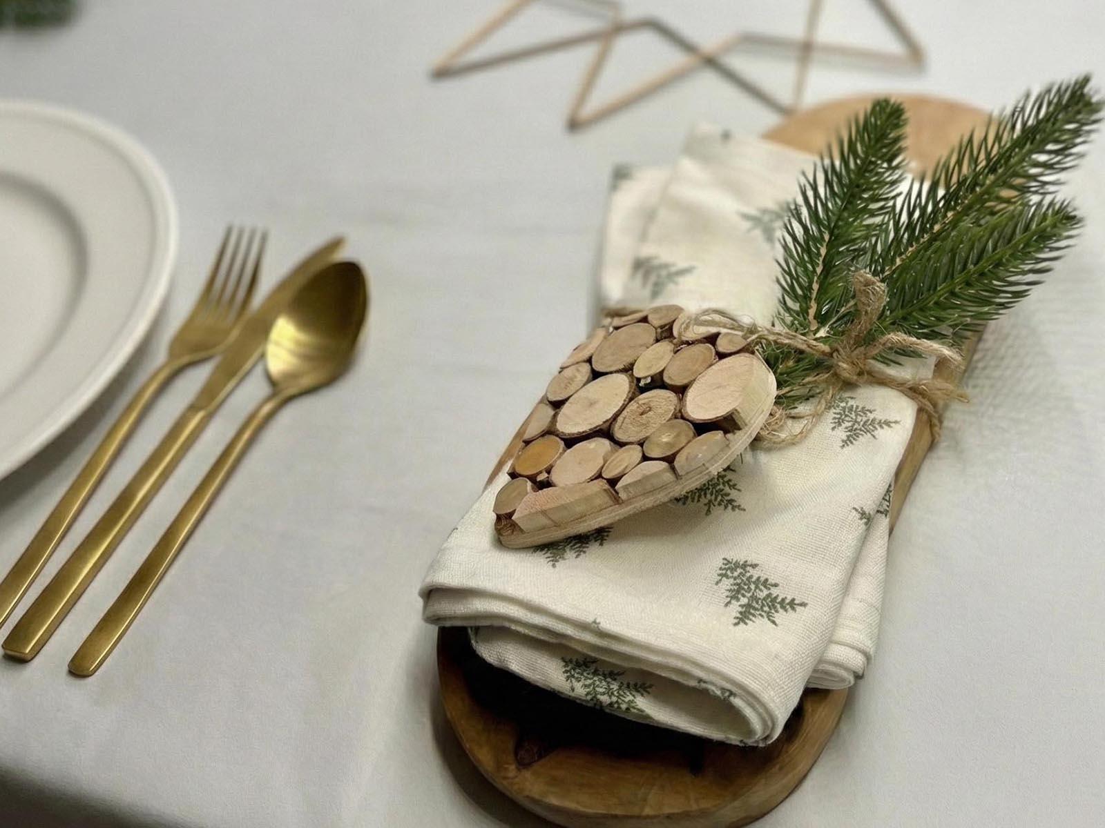 Ein Zweig eines k&uuml;nstlichen FairyTrees-Weihnachtsbaums, der an einer zusammengerollten Serviette mit einem Holzherz und einer Schnur befestigt ist, ist eine hervorragende M&ouml;glichkeit, einen alten Weihnachtsbaum wiederzuverwenden.